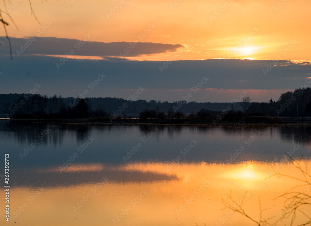 Early spring. Beautiful sunset on the wild nature. Forest river