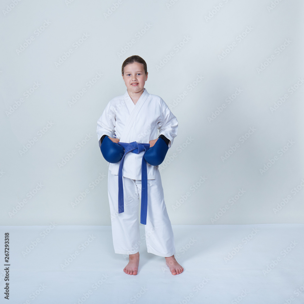 With a blue belt and blue overlays on the hands an athlete on a light background With a blue belt and blue overlays on the hands an athlete on a light background