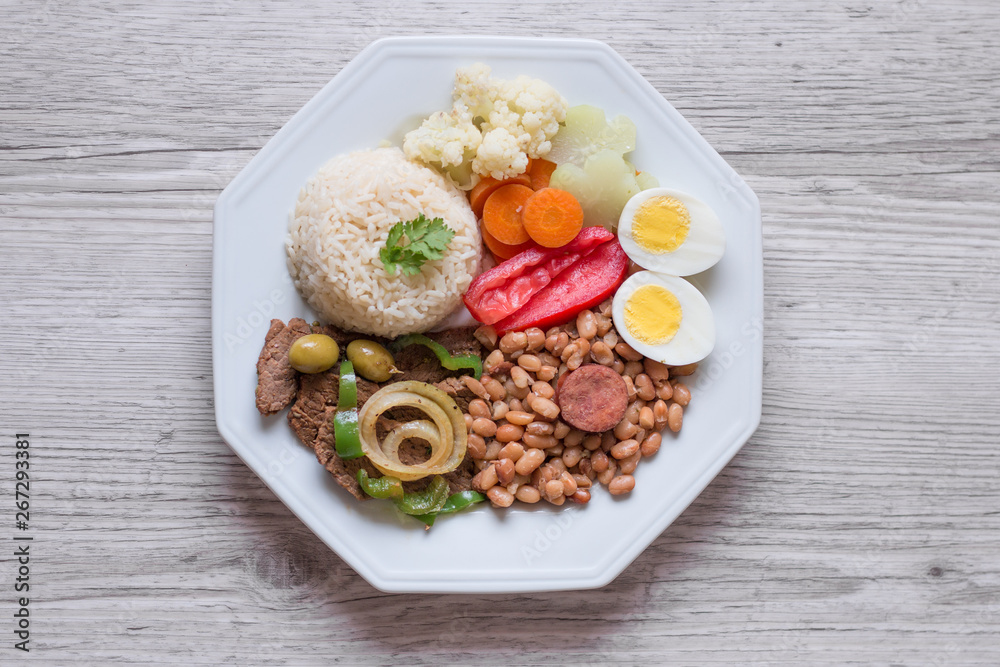 Brazilian food dish - Beans, rice, meat, eggs, salad