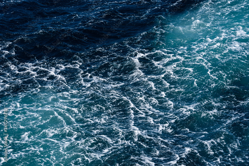 Fototapeta premium Turquoise and blue ocean water with bubbles and waves as a nature background