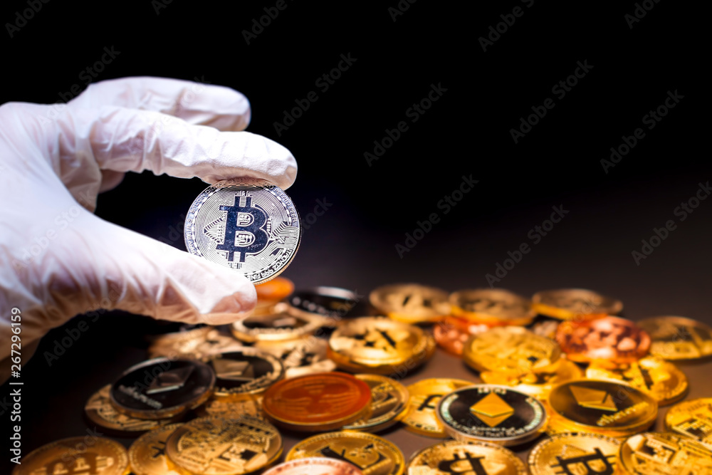 Hand holding a single silver bitcoin Hand holding a single silver bitcoin