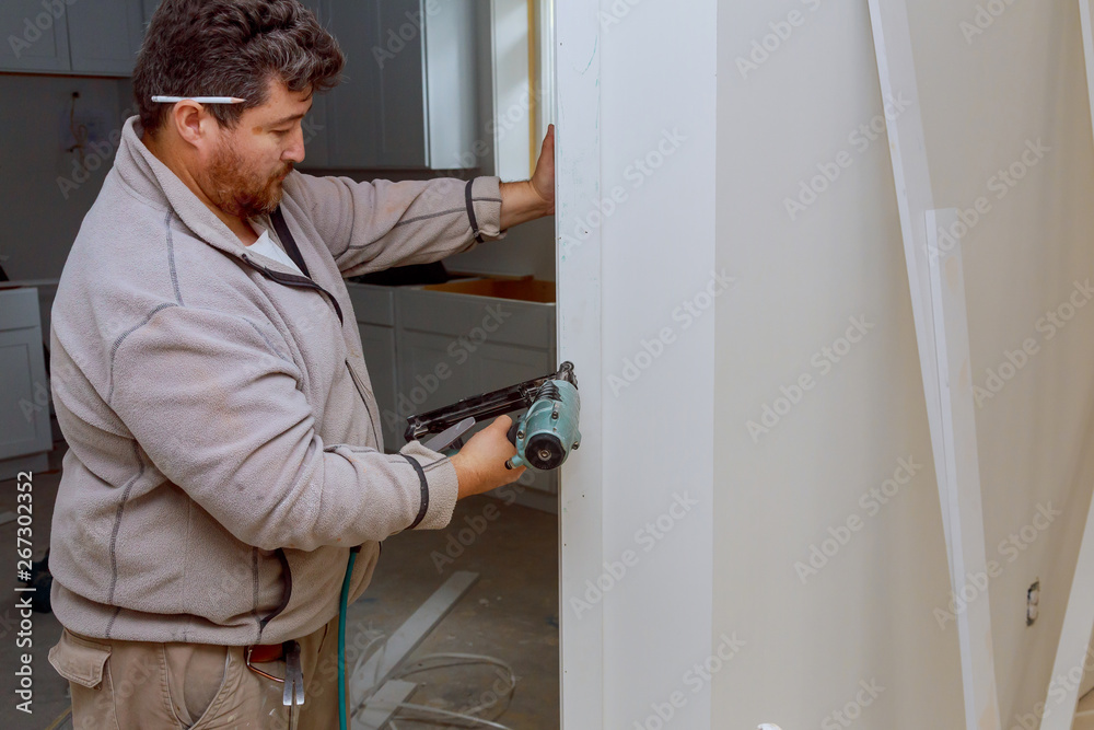 Installation of mouldings on the fragment of molding of using nail gun home improvements