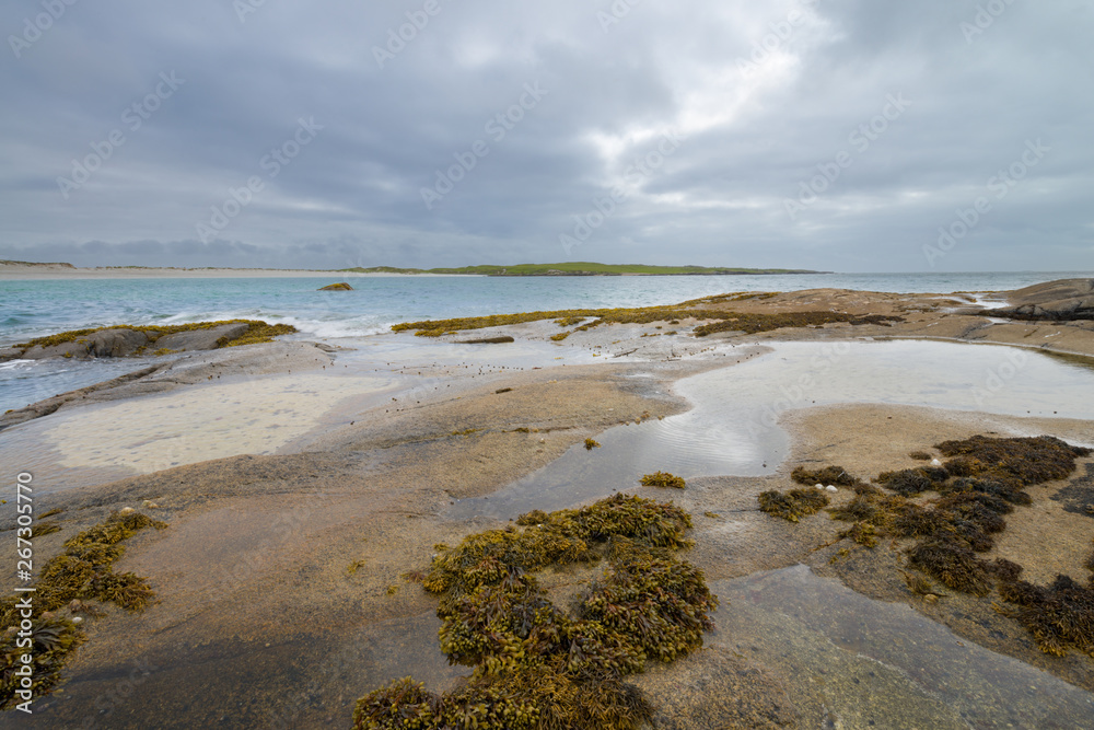 Glassilaun Beach and sandstone rocks with alga at low tide. Glassilaun beach is a beautiful white sandy beach situated between Renvyle and Killary bay, Galway, Ireland