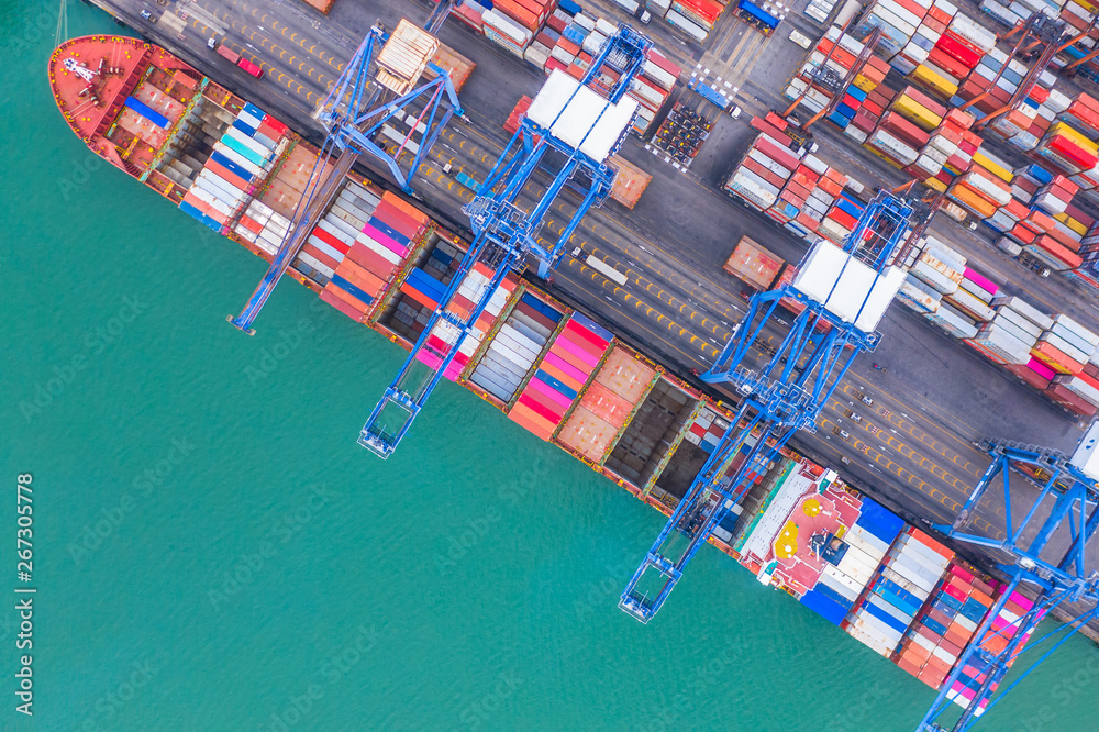 Container ship loading and unloading in deep sea port, Aerial top view of logistic import export transportation business by container ship in open sea.