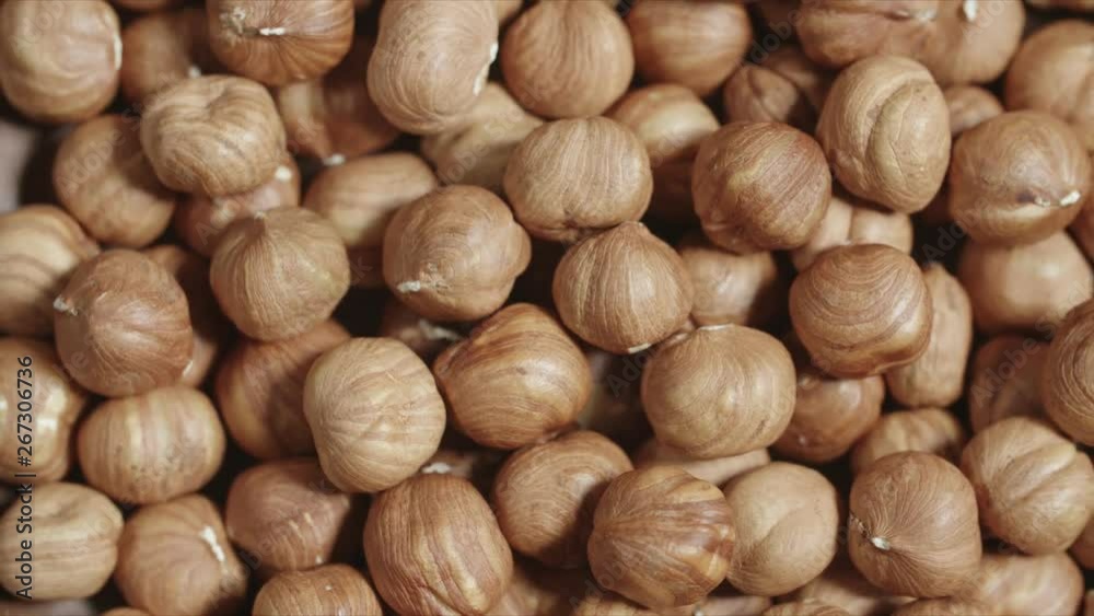 Peeled hazelnut rotating closeup in wooden bowl Peeled hazelnut rotating closeup in wooden bowl