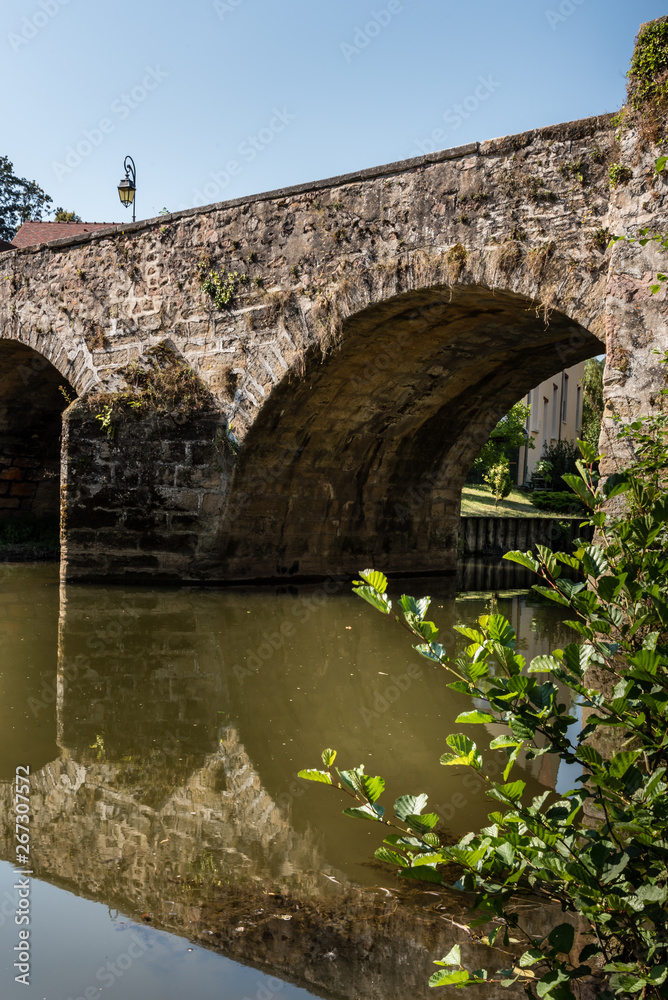 Along the quays under an old vaulted bridge in a French province in Semur