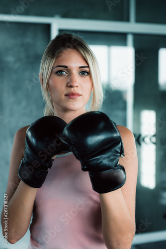 Female Boxer is Training Punching Exercised in Fitness Gym, Portrait of Boxing Woman in Sportswear and Boxing Gloves Practicing Exercising at Fitness Club. Sport Lifestyles and Healthcare Concept © Maha Heang 245789