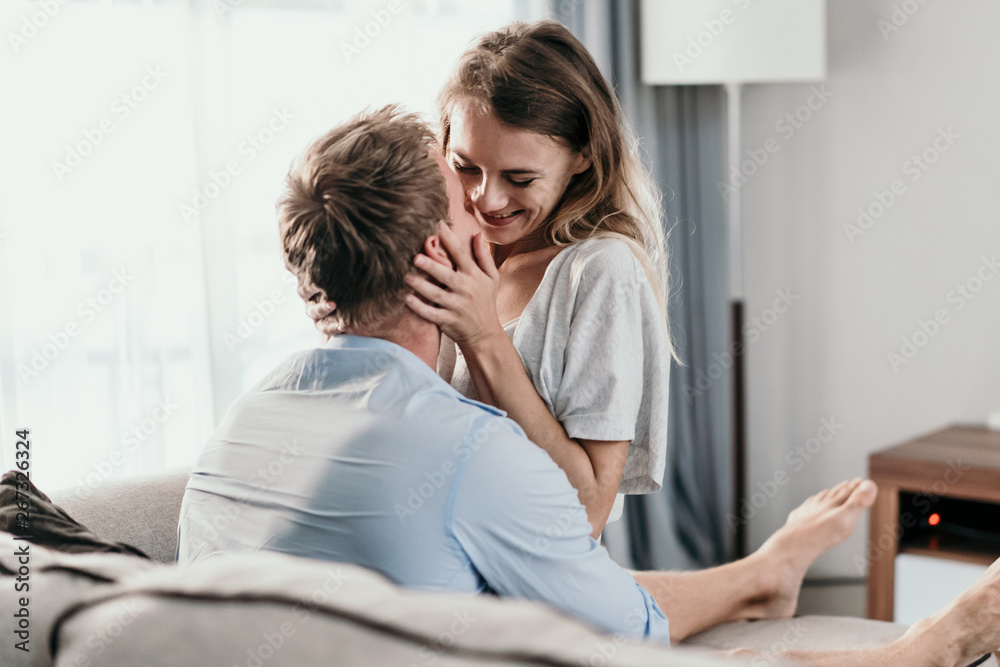 Beautiful young couple bonding and smiling while lying on the couch Beautiful young couple bonding and smiling while lying on the couch