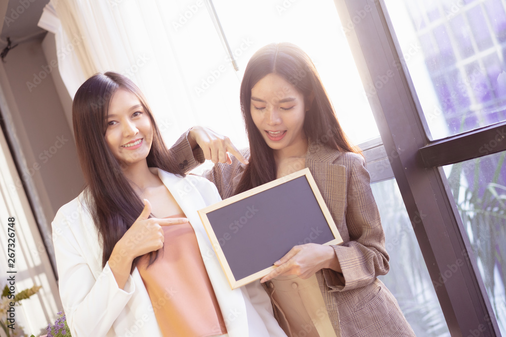 young Asian business woman holding a chalkboard.Successful business woman happy and smile.Idea note on blank blackboard. young Asian business woman holding a chalkboard.Successful business woman happy and smile.Idea note on blank blackboard.