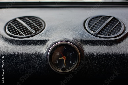 Black control panel with heater grilles and a clock with hands in an old Russian car © Илона Янкаускайте