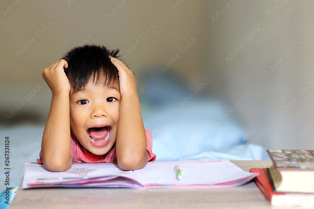 Asian student child boy have a headache and he feeling stressed because he get a lot of homework. Education and kid concept. Asian student child boy have a headache and he feeling stressed because he get a lot of homework. Education and kid concept.