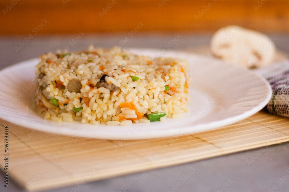 White plate with spicy pilaf with mushrooms White plate with spicy pilaf with mushrooms
