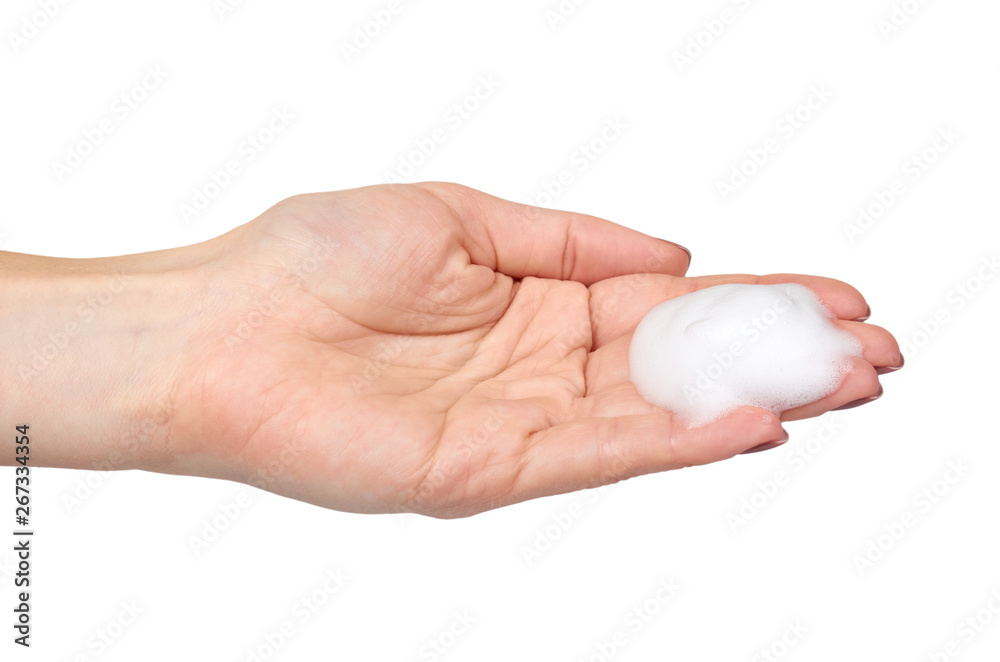 Hand with white foam bubbles, beauty smooth mousse, close up photo.