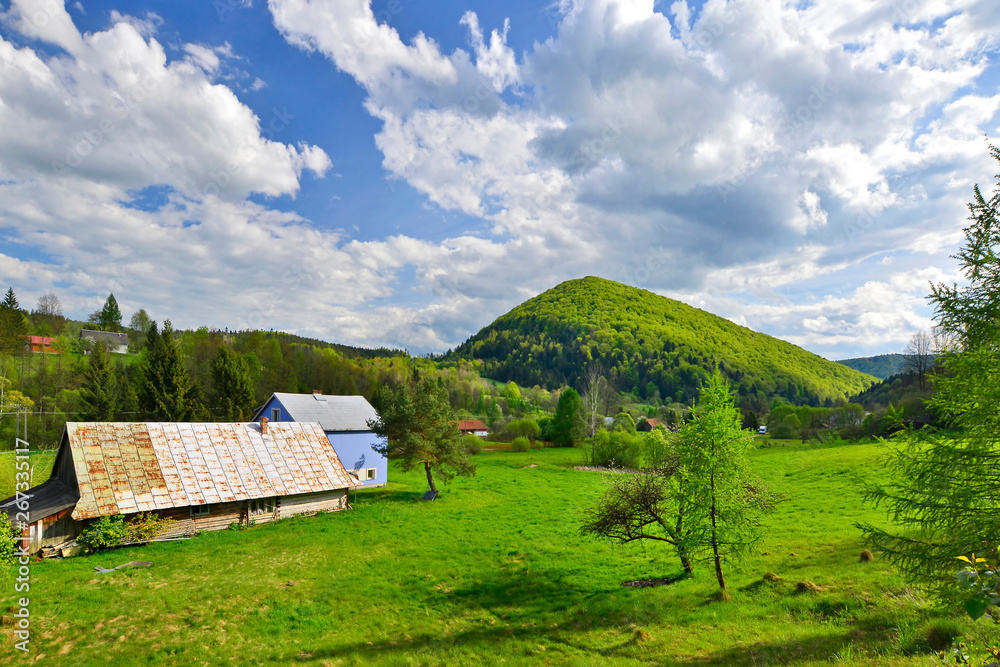 Rural landscape of small village surrounded by mountains and forests, Low Beskids (Beskid Niski), Poland
