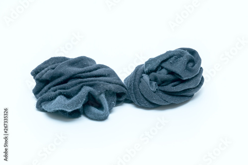 black dirty smelly men's socks crumpled in a pile on a white background