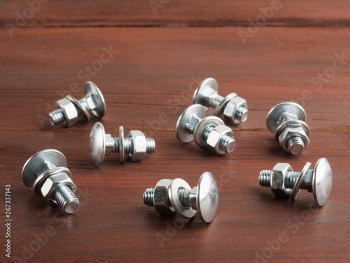 Set of screws, nuts and washers on a brown background. Industrial theme