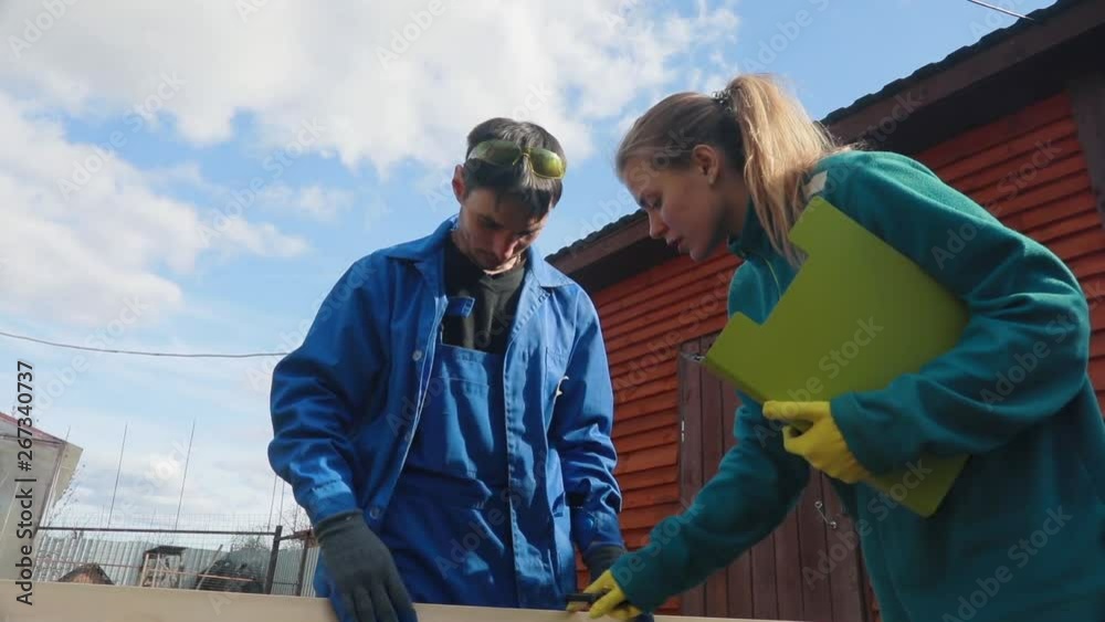 A young married couple at the ranch wants to make a table from natural boards. They refuse to use plastic. They discuss the quality of the boards and carry them to the place where the table is made. A young married couple at the ranch wants to make a table from natural boards. They refuse to use plastic. They discuss the quality of the boards and carry them to the place where the table is made.