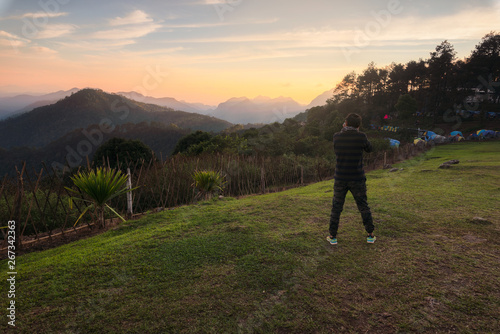 Young Asian men take pictures in the sunset view point of Doi Ang Khang.