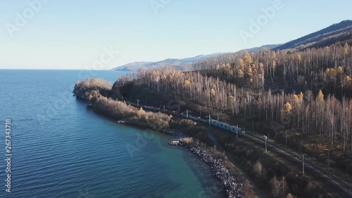 Winter day Aerial drone follow Trans-Siberian railway passengers tourist train near Baikal lake. Cinematic professional footage. High altitude