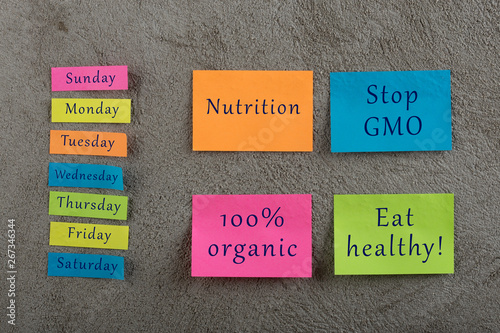 Diet plan concept - Many colorful sticky note with words nutrition, eat healthy, stop gmo, 100 percent organic and days of week