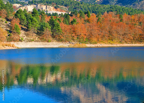 Tsivlou lake at the banks of Helmos mountain in Peloponnese, Greece. Beautiful colorful nature scene of a lake with multicolored trees and their reflections.