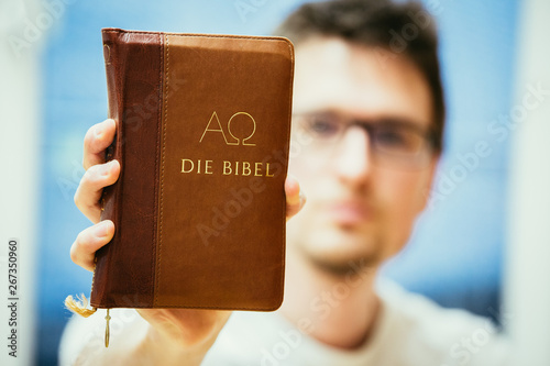 Photography Christian preacher: Young man is holding the bible, praying
