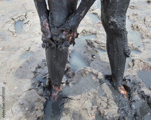 Εκτύπωση καμβά Smearing black healing mud on the leg.