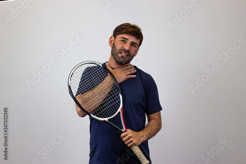 Portrait of handsome young man playing tennis holding a racket with brown hair looking anguished or bitter, looking at the camera. Isolated on white background. © Sergio Barceló
