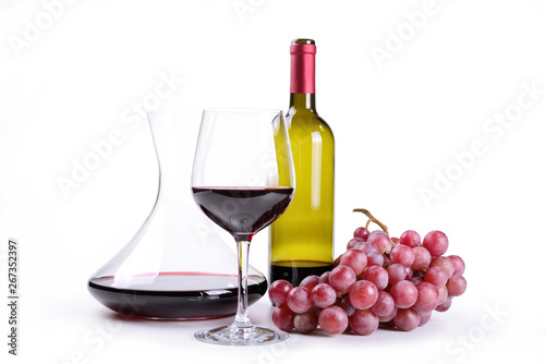 Glass of red wine with decanter and bunch of grapes