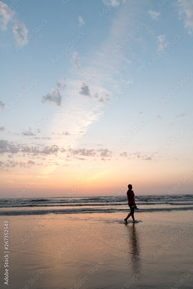 Silhouette of youth walking at Juhu beach