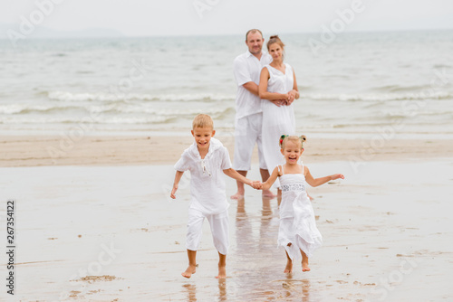 Happy young family on the sunset at the beach. © romaset