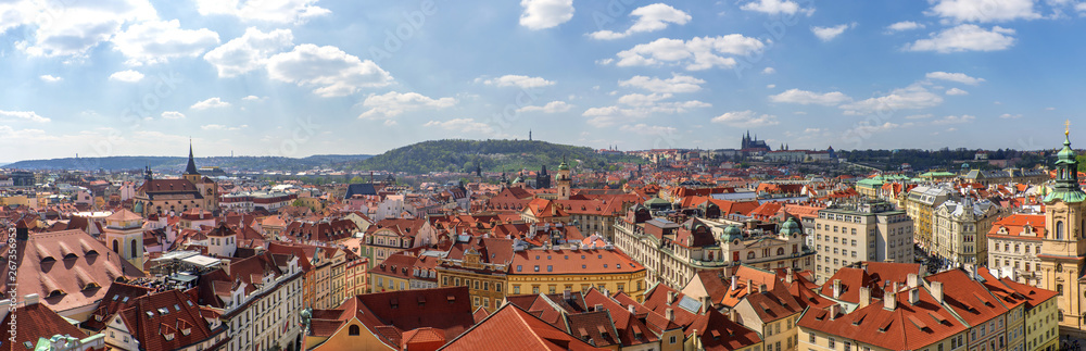 Outdoor sunny panoramic aerial scenery of rooftop in old town, city skyline, Charles Bridge tower and background range of mountain with Prague Castle and St. Vitus Cathedral in Prague, Czech Republic.
