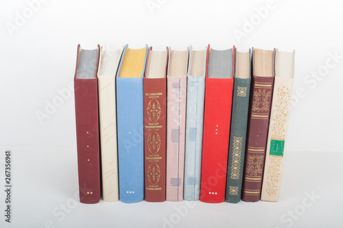 Book stacking. Open book, hardback books on wooden table and white background. Back to school. Copy space for text