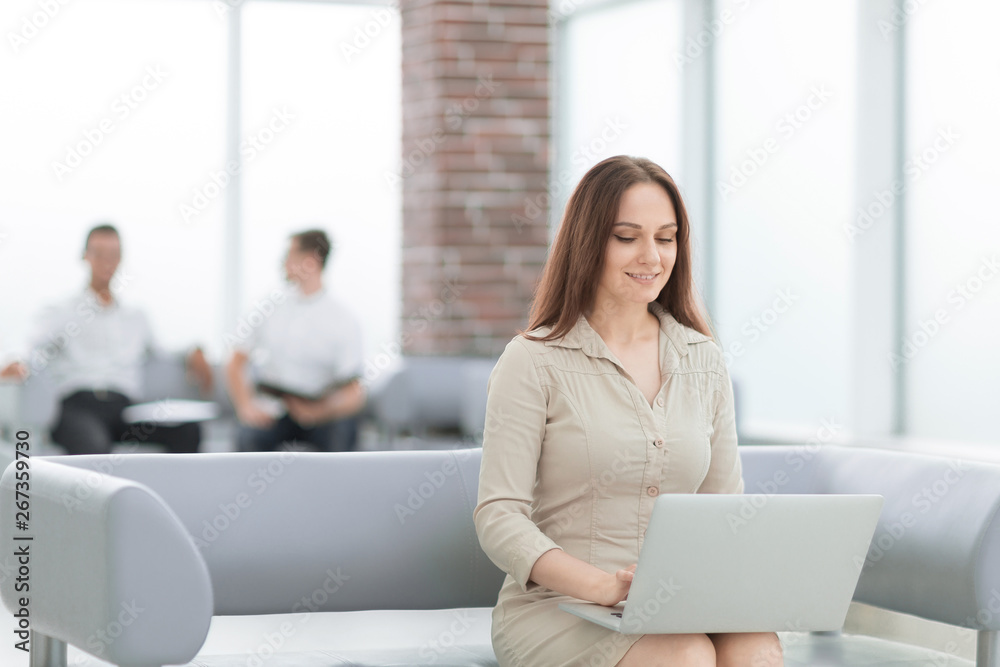 Young business woman sitting at sofa and working with laptop Young business woman sitting at sofa and working with laptop