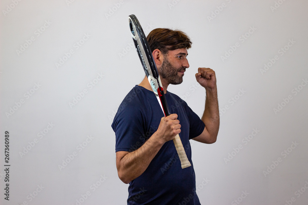 Portrait of handsome young man playing tennis holding a racket with brown hair looking with lust, facing forwards and looking at the side. Isolated on white background. Portrait of handsome young man playing tennis holding a racket with brown hair looking with lust, facing forwards and looking at the side. Isolated on white background.