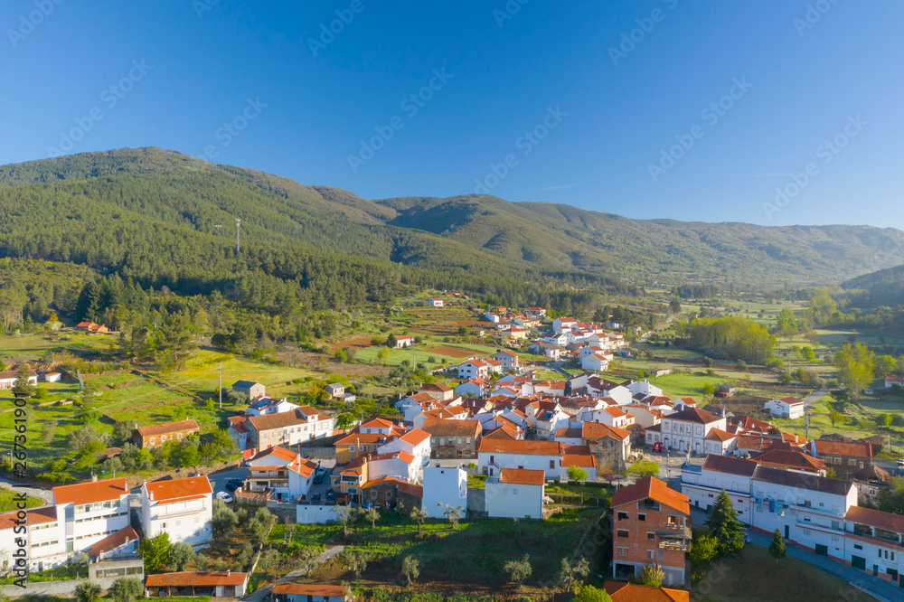 Fototapeta premium Aerial view of small town with red roofs during sunrise time. Top View of Valhelhas village in central Portugal