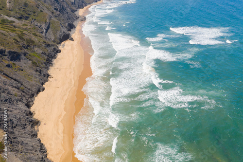 Atlantic ocean sandy beach with turquoise ocean and waves. Aerial view of Cordoama beach in Portugal