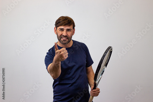 Portrait of handsome young man playing tennis holding a racket with brown hair clapping hands, looking at the camera. Isolated on white background.
