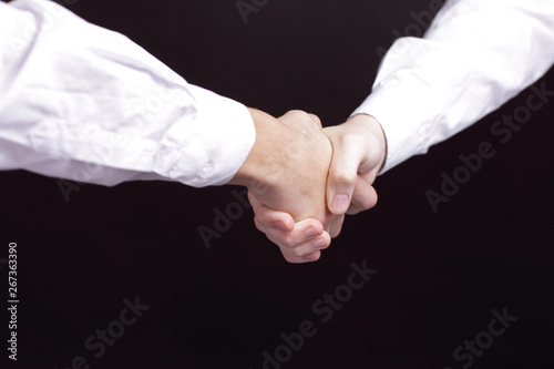 close up. handshake business partners. isolated on black background