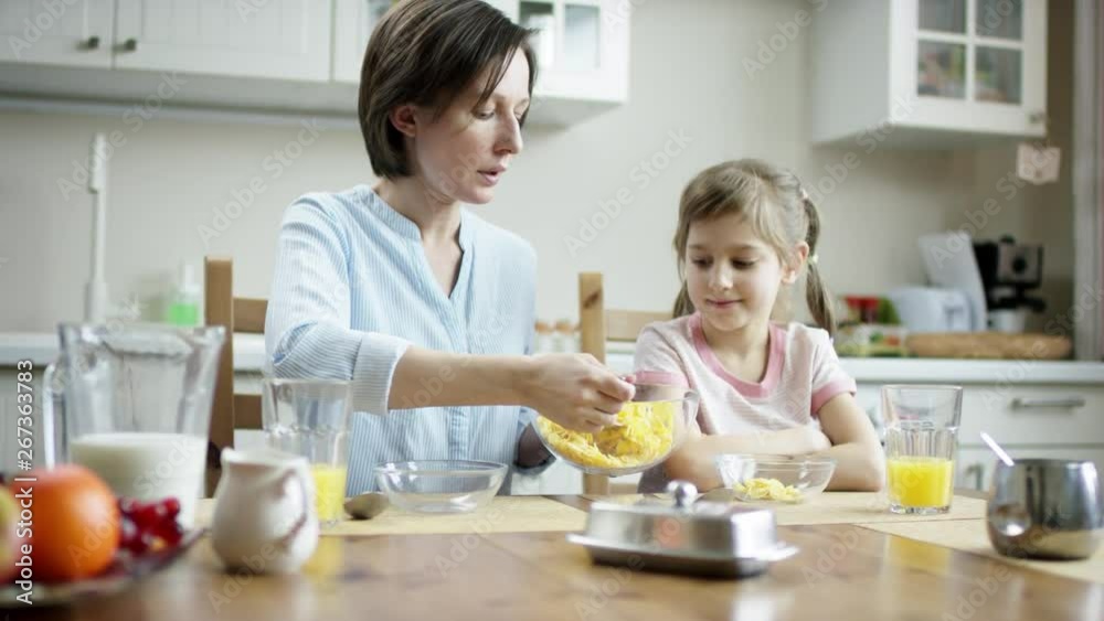 mother put cornflakes to her daughter then to herself mother put cornflakes to her daughter then to herself