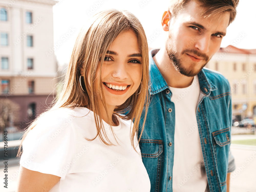 Smiling beautiful girl and her handsome boyfriend in casual summer clothes. Happy cheerful family having fun on the street background Smiling beautiful girl and her handsome boyfriend in casual summer clothes. Happy cheerful family having fun on the street background