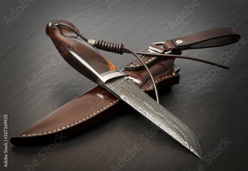Hunting knife handmade on a black background. Leather Sheath Handmade