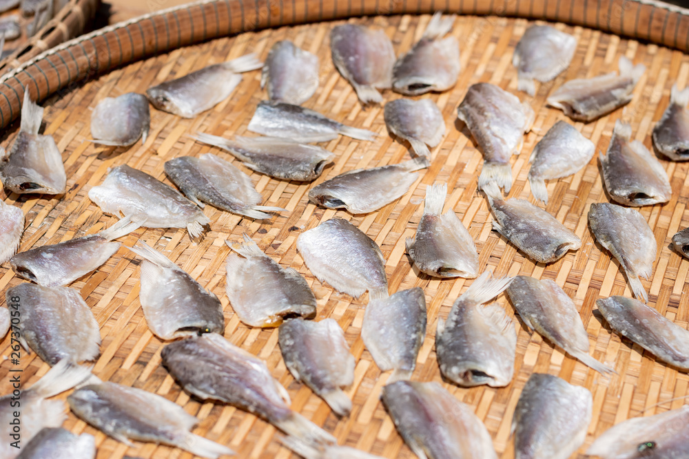 Naklejka premium Make dry fish with sunny on bamboo basket. Salted fish dries on threshing basket.