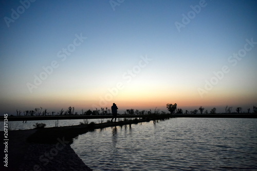 Silhouette Man and Baby at Lake on the sunset at Al Qudra love lake, Dubai, United Arab Emirates photo