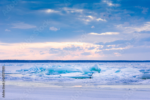Beach in wintertime. Frozen sea, evening light and icy weather on shore like fairy tale country. Winter on coast. Blue sky, white snow, ice covers the land. © Artenex