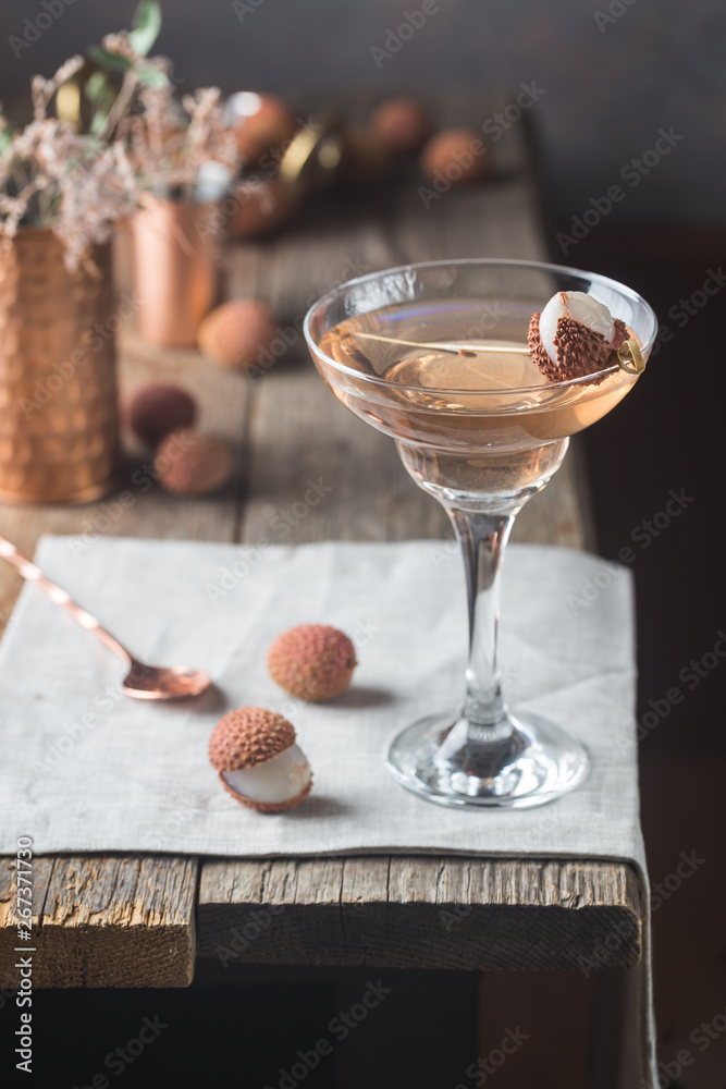 Glass of cold lychee cocktail on the old wooden table, rustic style - obrazy, fototapety, plakaty 
