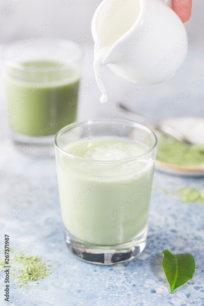 Iced Matcha green latte in glasses with matcha powder on light background. Iced Matcha green latte in glasses with matcha powder on light background.