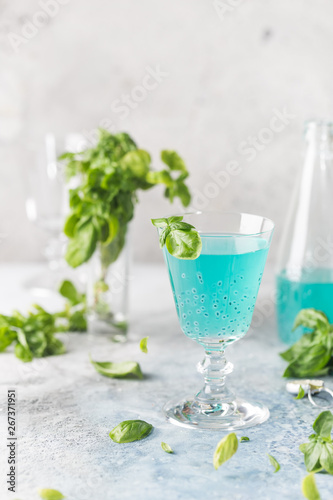 Colorful refreshing summer drink with basil seeds on light background.