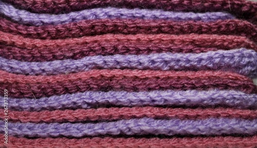 Colorful violet and purple design background of knitted woolen elements in a pale © lipchania