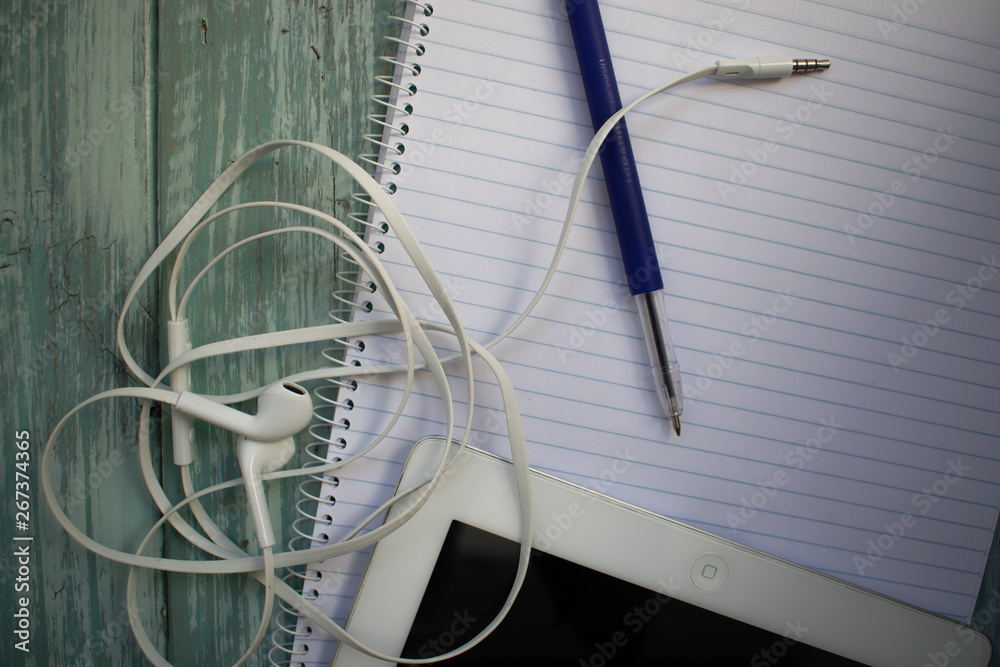 phone headphones, notebook, tablet and pen on the desktop phone headphones, notebook, tablet and pen on the desktop